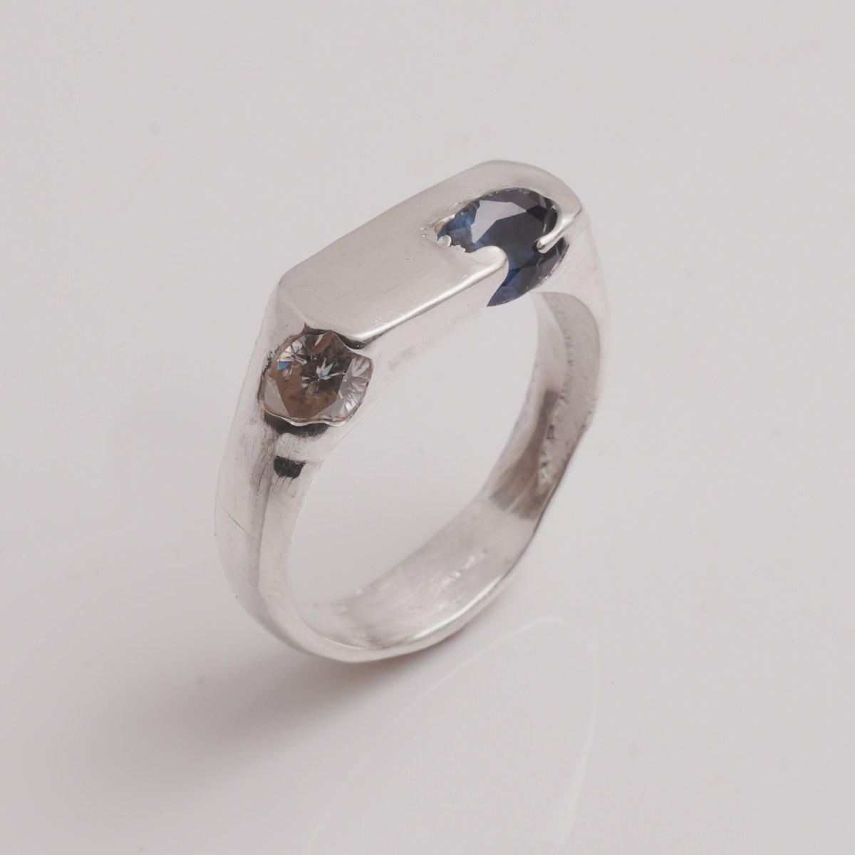 OIAM No. 8, sterling band set with an oval blue sapphire and a white accent stone